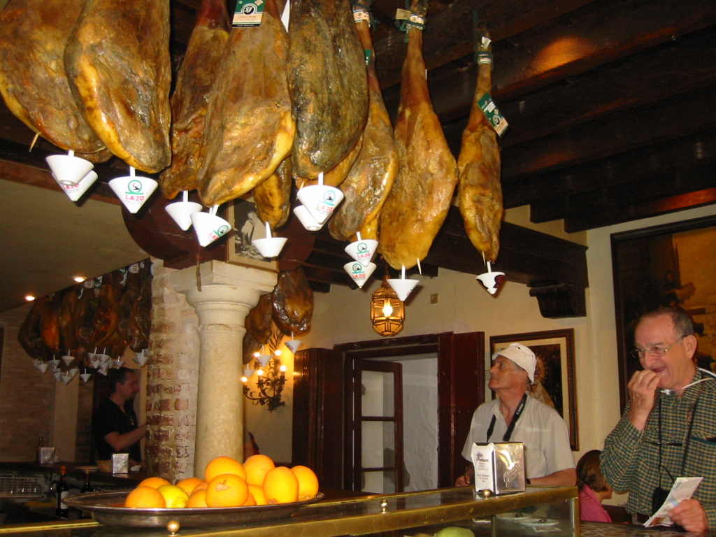 Sevilla - słynne jamón iberico dochodzą nad barem w dymie papierosowym